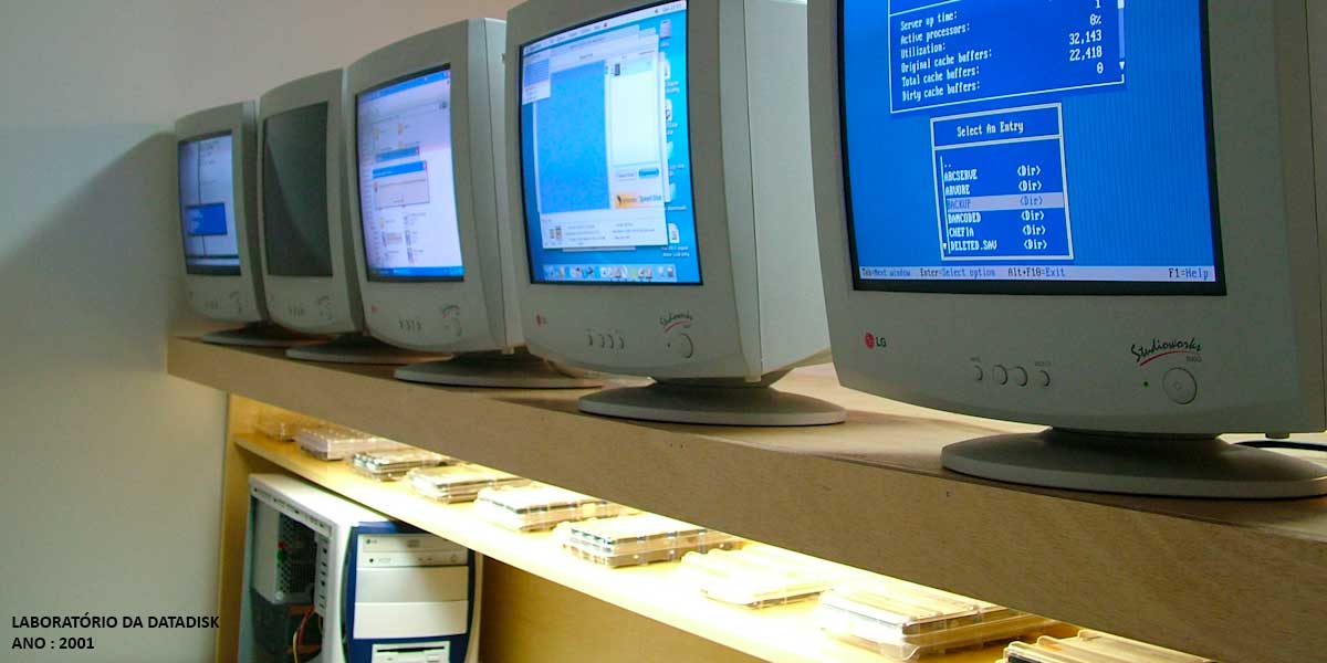 Registro histórico do laboratório da DATADISK em 2001 com monitores de tubo Samsung SyncMaster 3 utilizados em processos técnicos de recuperação de dados.